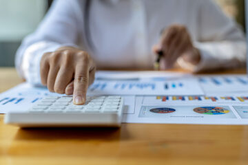 An individual computing his tax using a calculator and some data.