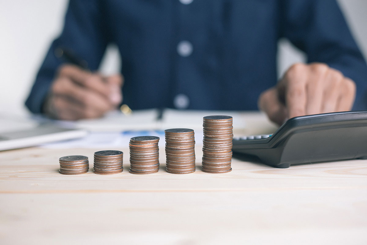 Some coins and a calculator in front of a Tax Agent