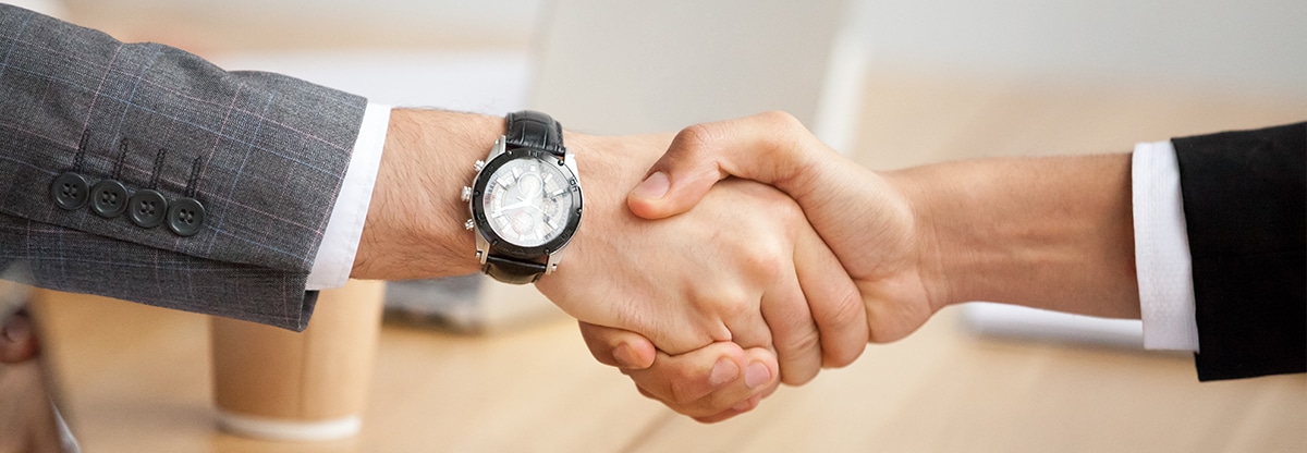 Image of hands of businessmen in a handshake after a deal.